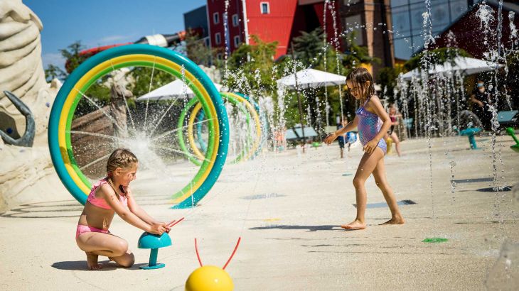 Kinder spielen mit Wasserspielen am Snorri Strand