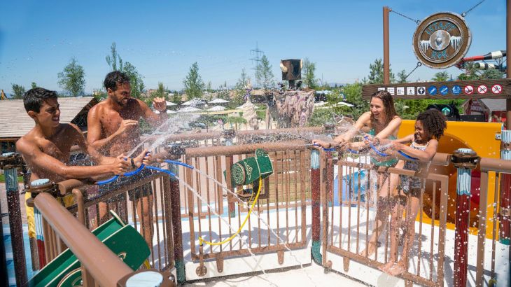 Eine Familie macht eine Wasserschlacht in der Outdoor-Rutschenwelt Svalgurok