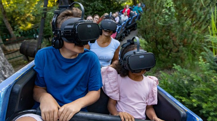 Eine Familie fährt mit dem Alpenexpress "Enzian" und trägt eine VR-Brille