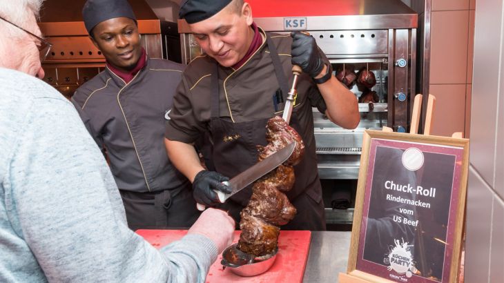 Köche schneiden Fleisch vom Spieß