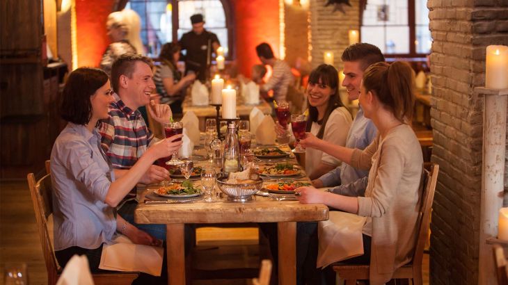 Freundesgruppe sitzt  im Restaurant Castillo gemeinsam am Tisch und isst