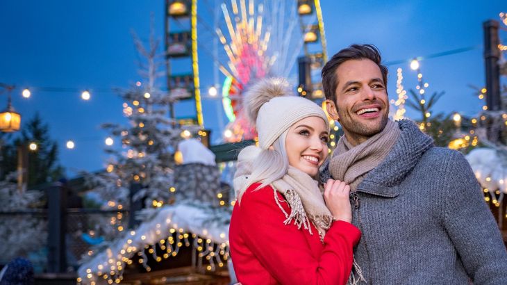 Ein Paar in warmer Kleidung steht vor dem Riesenrad Bellevue