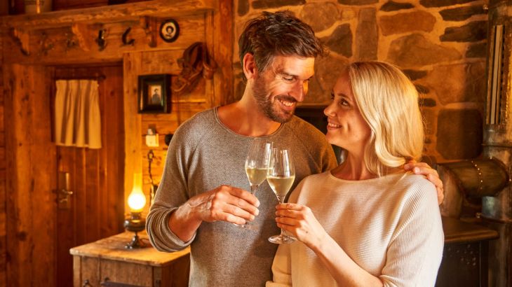 Pärchen lächelt sich an und halten ein Glas Sekt