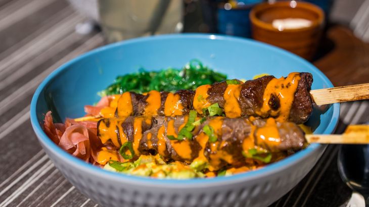 Leckere Hawaii-Bowl mit Fleisch in einer blauen Schale