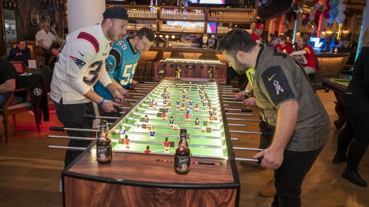 Vier Männer spielen in der Halbzeit Kicker