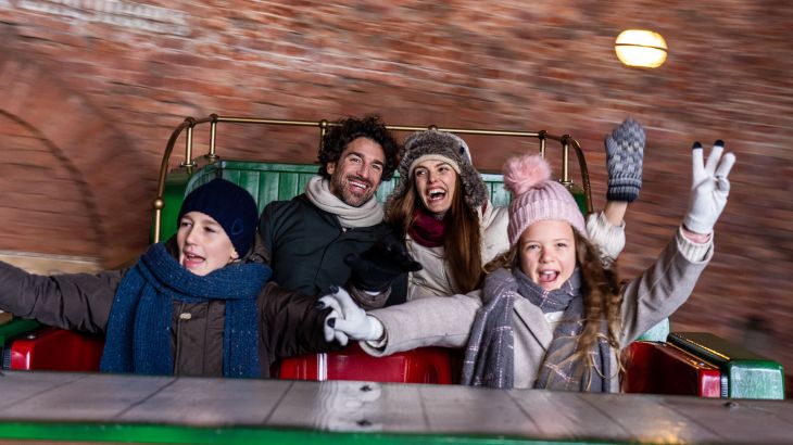 Familie in winterlicher Kleidung im Dancing Dingie im Themenbereich Irland