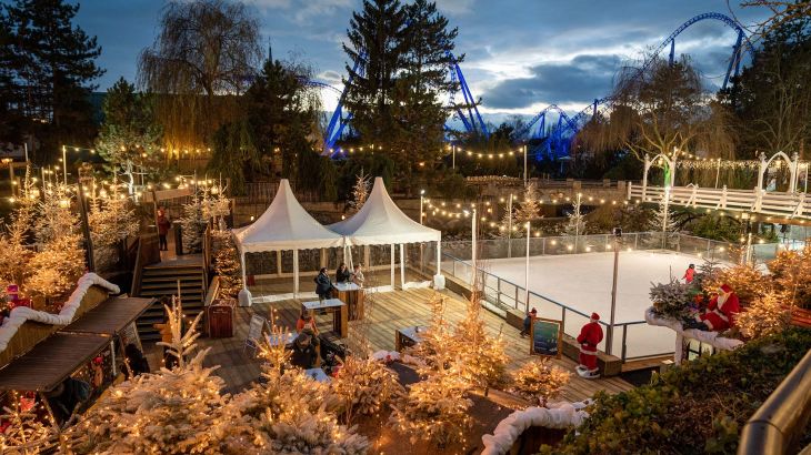 Beleuchtetes nordisches Dorf mit Eislauffläche