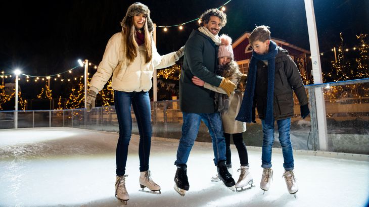 Familie beim eislaufen im Nordischen Dorf