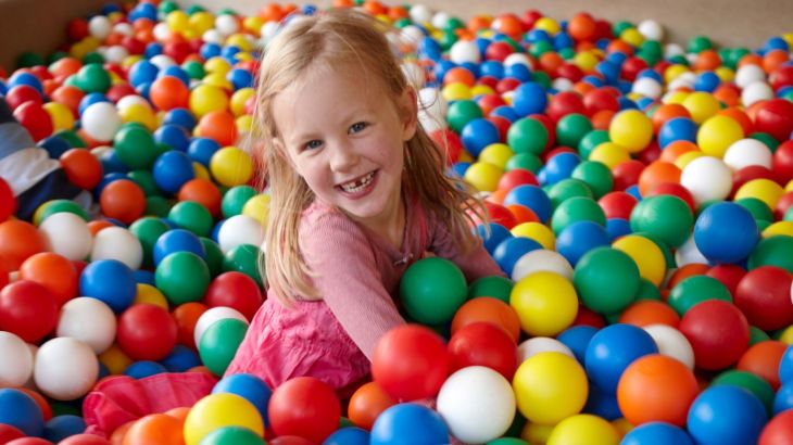 Kleines Mädchen im Ballpool im holländischen Themenbereich