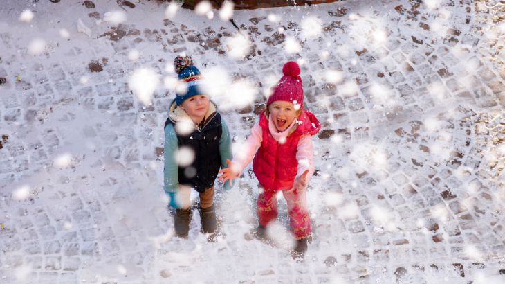 Kleine Kinder werden beschneit durch Frau Holle