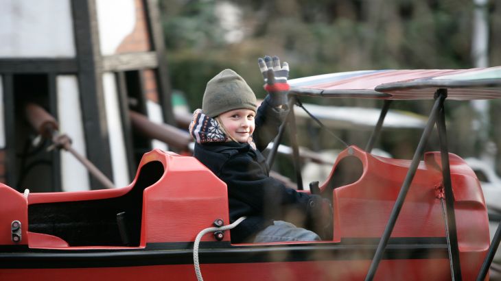Kleiner Junge im Fahrgeschäft roter Baron im Themenbereich Holland