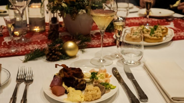 Mit skandinavischen Speisen bestückter Teller auf einem festlich gedeckten Tisch