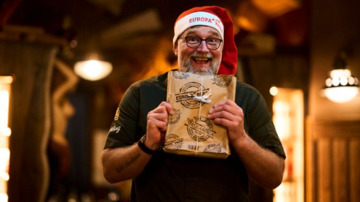 TV-Koch Brian Bojsen mit Weihnachtsmütze und einer Europa-Park Tüte in der Hand
