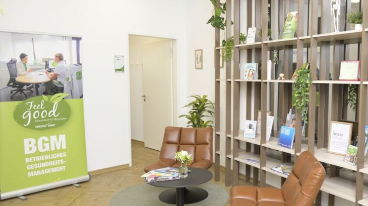 Eine Warteecke in den Feel Good Räumlichkeiten mit gemütlichen Sesseln und Informationsmaterialien zum Angebot.