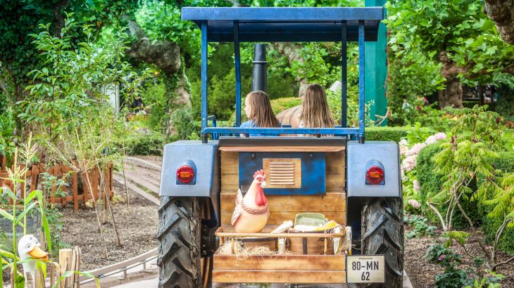 Zwei Kinder fahren mit der Old Mac Donald's Tractor Fun durch abenteuerliche Landschaften.