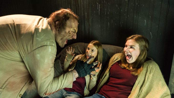 Ein Darsteller der Terenzi Horror Nights erschreckt zwei Besucherinnen des Events.
