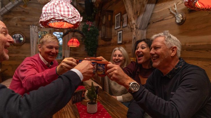 A team clinks glasses in the ERDINGER Hütt'n at Europa-Park.