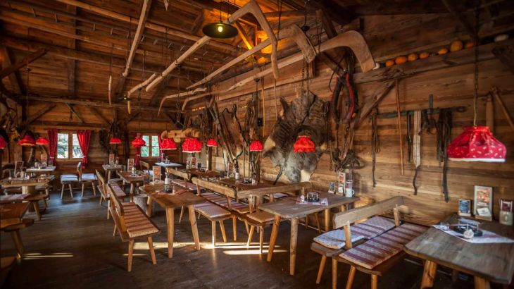 The cosy ERDINGER Hütt'n with rustic wooden benches and authentic decorations on the walls.