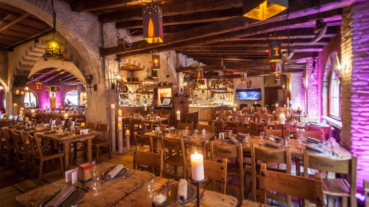 Interieur in middeleeuwse stijl van restaurant Castillo met veel zitplaatsen.