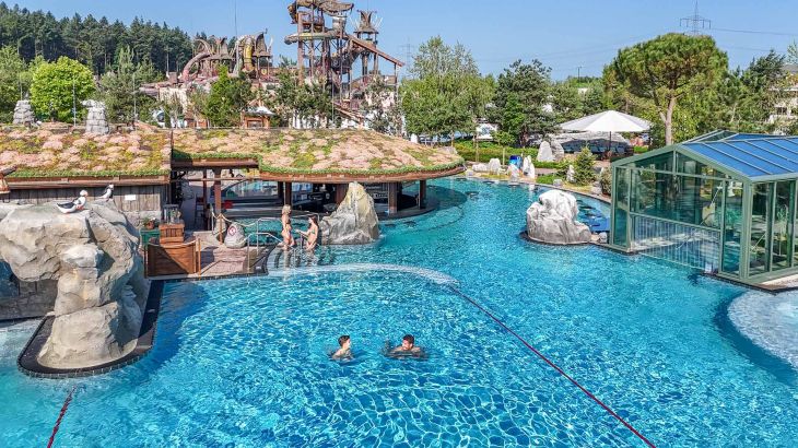Gäste plantschen ausgelassen im großen Outdoor-Pool Svømmepøl in Rulantica.