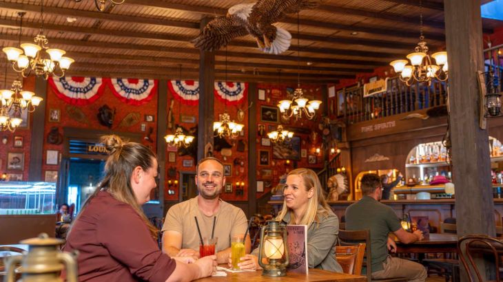 Eine Freundesgruppe genießt köstliche Drinks im Wild-West-Ambiente der Wild Horse Bar.