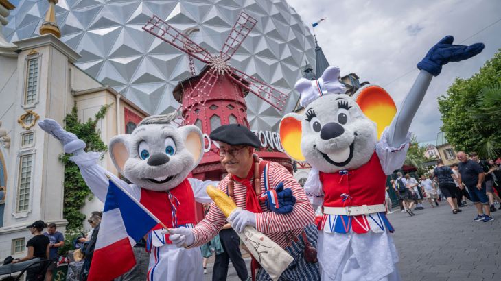Ed ed Edda nel quartiere francese dell’Europa-Park, ridono con una persona allegra che tiene in mano una baguette.