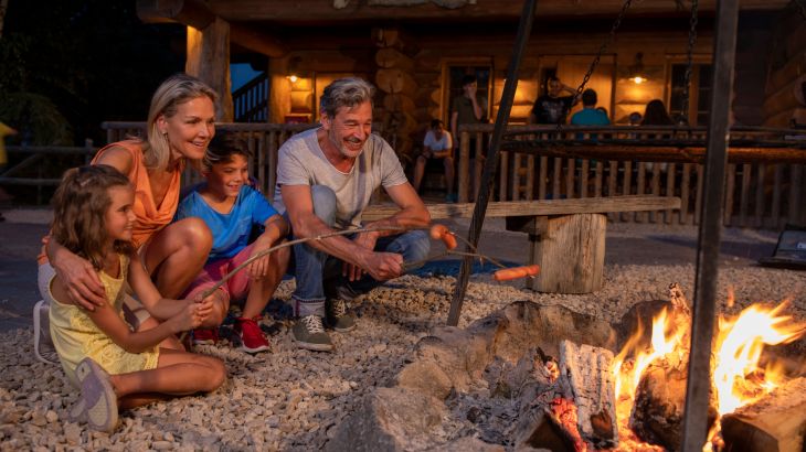 Senioren mit Enkelkindern am Lagerfeuer