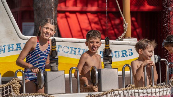 Kinder spielen mit Wasserpistolen