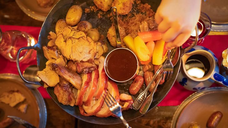 Eine große Pfanne mit Fleisch, Kartoffeln und Soße.
