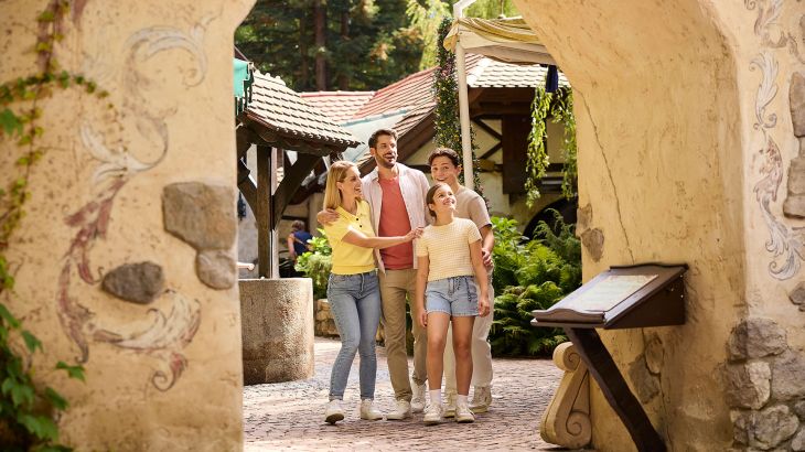 Eine staunende Familie im Themenbereich Grimms Märchenwald.
