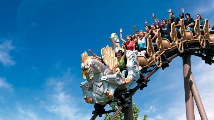 Famille à bord de l’attraction Pegasus - le grand huit familial à Europa-Park en été.