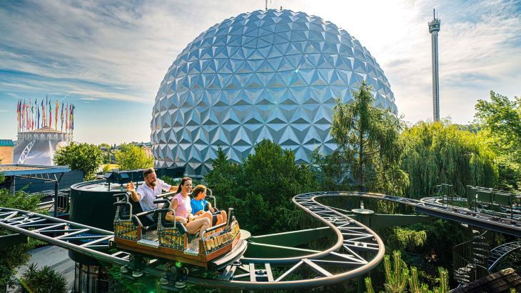Eine Familie auf der Attraktion Matterhorn-Blitz, im Hintergrund sieht man die Kugel der Eurosat.