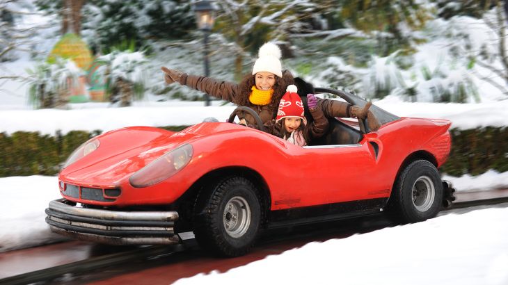 Mère et fille à bord d’une voiture de course de la Piste Silverstone alors qu’Europa-Park est couvert d’un manteau de neige.