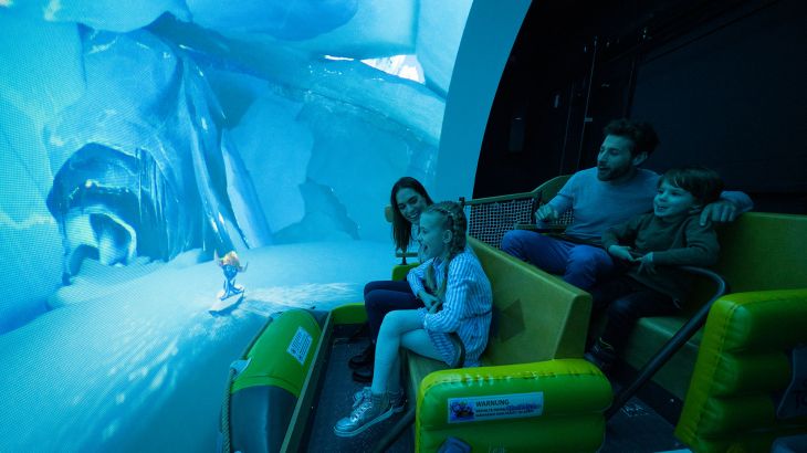 Una famiglia sull’attrazione Snorri Touren - Tour di Snorri nel quartiere tematico scandinavo dell’Europa-Park. Si vede uno schermo che mostra Snorri in una grotta di ghiaccio.