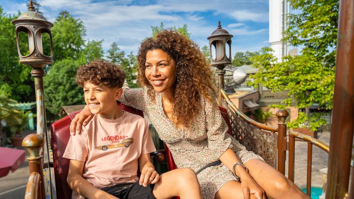 Une mère avec son fils à bord de l’attraction Volo da Vinci.