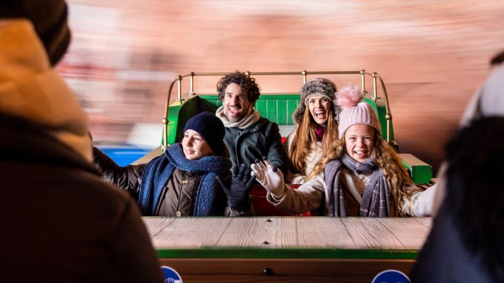 Eine Familie während der Fahrt mit der Attraktion Dancing Dingie im Irischen Themenbereich.