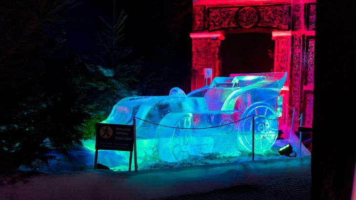 Ein blau beleuchtetes, aus Eis geschnitztes, Rennauto.