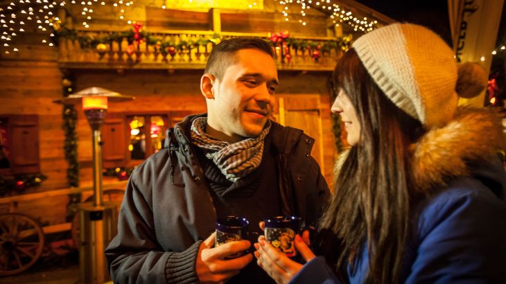 Ein Paar steht zusammen vor der Erdinger Hütt'n.