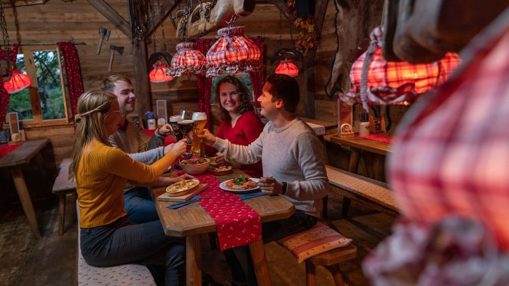 Vier Gäste stoßen gemeinsam in der ERDINGER Hütt'n an.