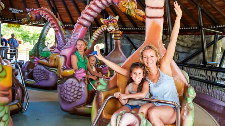 Eine Mutter mit ihrer Tochter im Drachenkarussell Spinning Dragons.