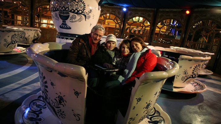 Eine Familie in dem Koffiekopjes Karussel.