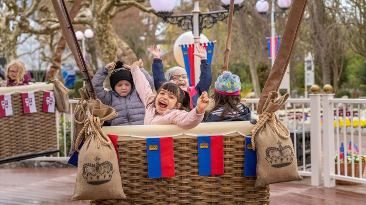 Vier Kinder in einer der zehn Gondeln des Ballonkarussells im Liechtensteiner Themenbereich.