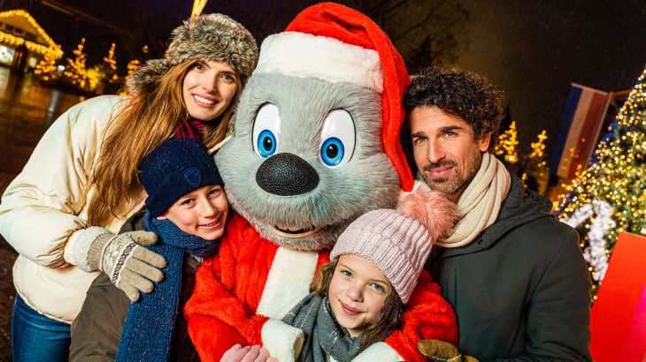 Eine Familie zusammen mit Ed Euromaus, welcher als Weihnachtsmann verkleidet ist.