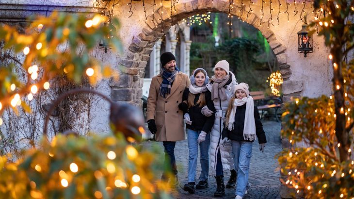 Eine vierköpfige Familie bewundert die schönen Lichter in Grimms Märechenwald.
