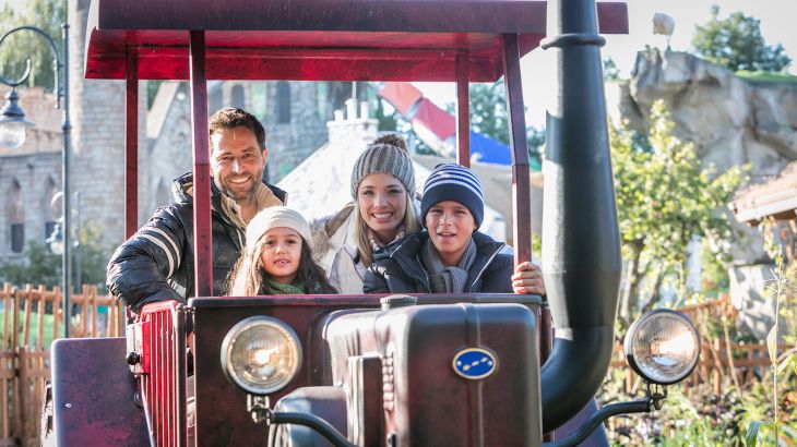 Eine Familie in einem Traktor der Attraktion Old Mack Donald Tractor Fun.