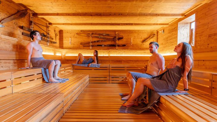 Mehrere Personen entspannen mit Gesichtsmasken in der Sauna "lille".