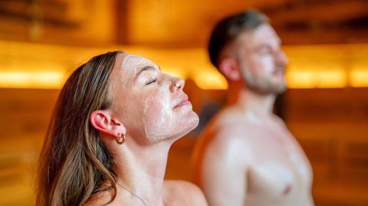 Zwei Personen entspannen mit Gesichtsmasken in der Sauna "lille".