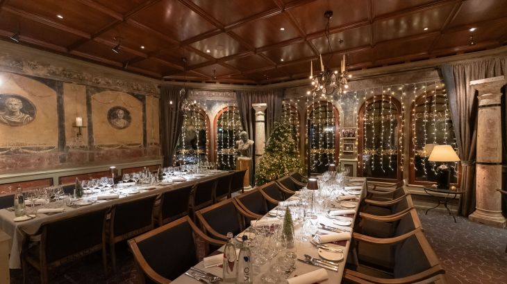 Weihnachtlich geschmückte und eingedeckte Tische im Restaurant Cesare