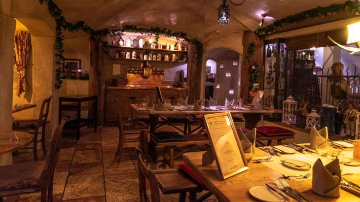 De Klosterkeller van het 4‑sterren superior themahotel "Santa Isabel", met houten meubilair dat de ruimte een warme en rustieke sfeer geeft.