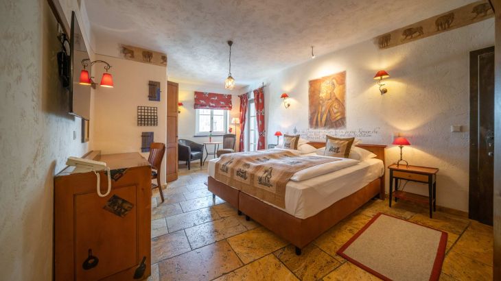 Deluxe-Zimmer mit Doppeltbett, Fernseher, Schreibtisch, Stuhl und Fenster
